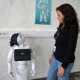 Liten robot sammen med kvinnlig forsker, ser på hverandre. Foto.