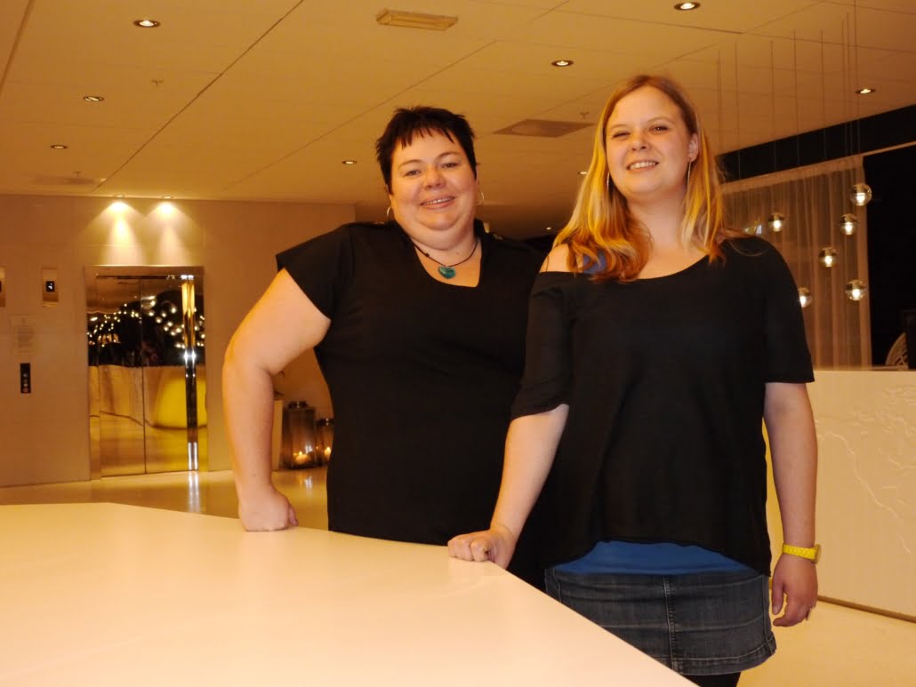 To personer begge ikledt sort tøy bak et hvitt bord. Foto.