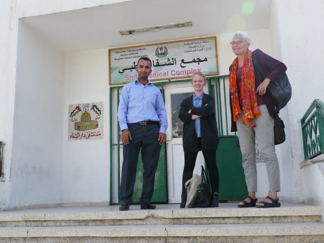 Tre personer på en trapp, ser inn i kamera. Foto. 