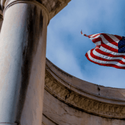 det amerikanske flagget mot blå himmel, og del av pillar ved historisk bygg. illustrasjonsfoto.