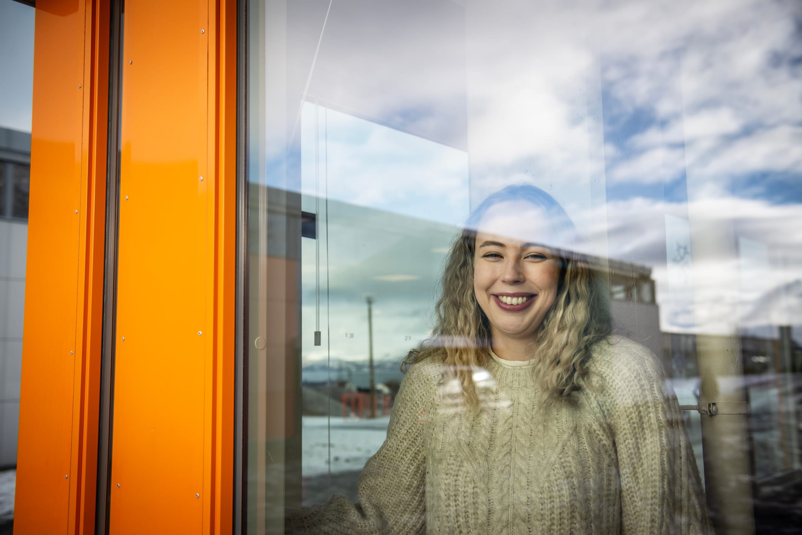 ung kvinne smiler sett gjennom glassrute. foto.