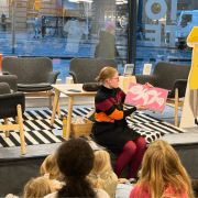 person som viser bok med bilder til samling av barn. foto.