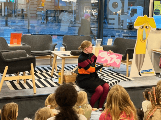 person som viser bok med bilder til samling av barn. foto.