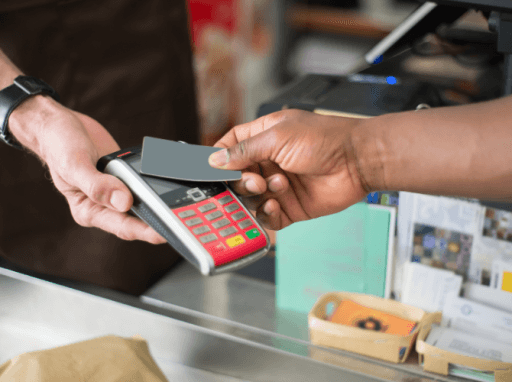 bildet viser hender som holder betalingskort over kortautomat, gjennomfører transaksjon. foto.