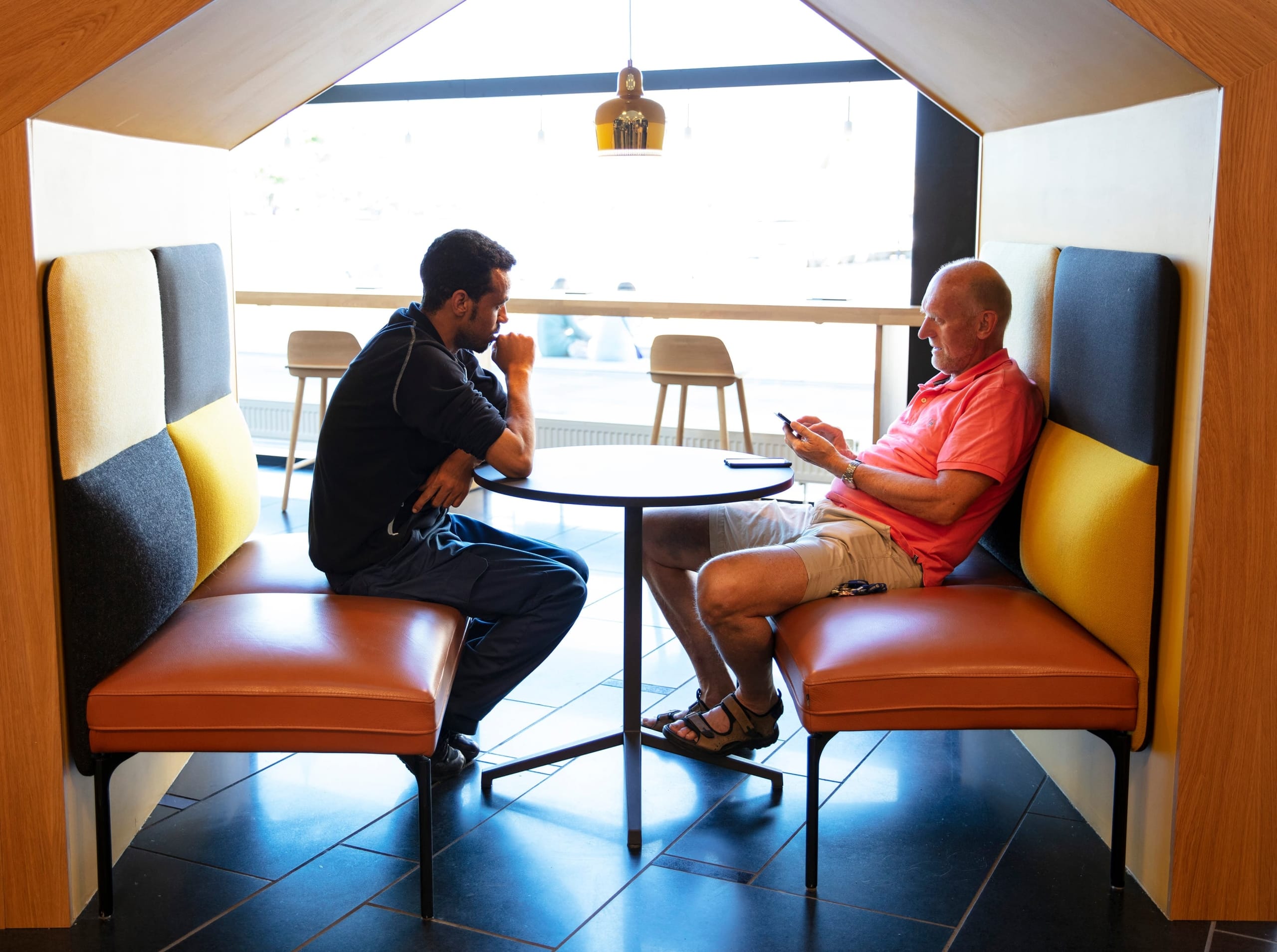 to personer ved et bord i et bibliotek konsentrert om hver sine ting. foto.