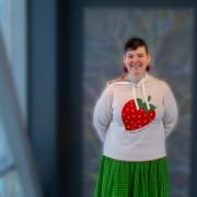 portrait of person (sam helmick) in white sweater with strawberryprint. foto.