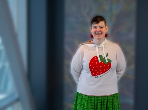 portrait of person (sam helmick) in white sweater with strawberryprint. foto.