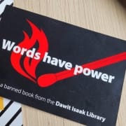 brosjyre med teksten "Words have power" fra the dawit isaak library ligger på en bordflate. foto