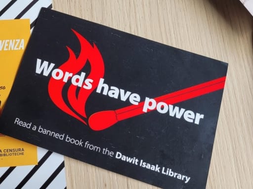 brosjyre med teksten "Words have power" fra the dawit isaak library ligger på en bordflate. foto